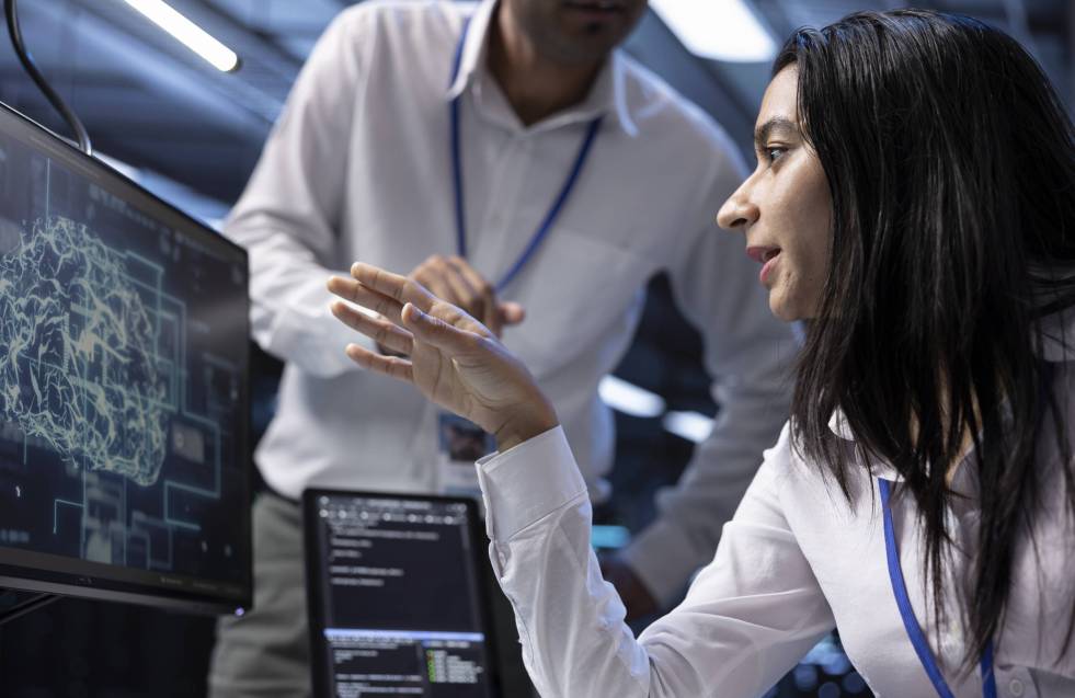 Coworkers using AI tech to fix errors in server farm providing storage Coworkers using AI tech to fix errors in server farm providing storage. IT staff members in data center using PC to enable artificial intelligence to process datasets for training